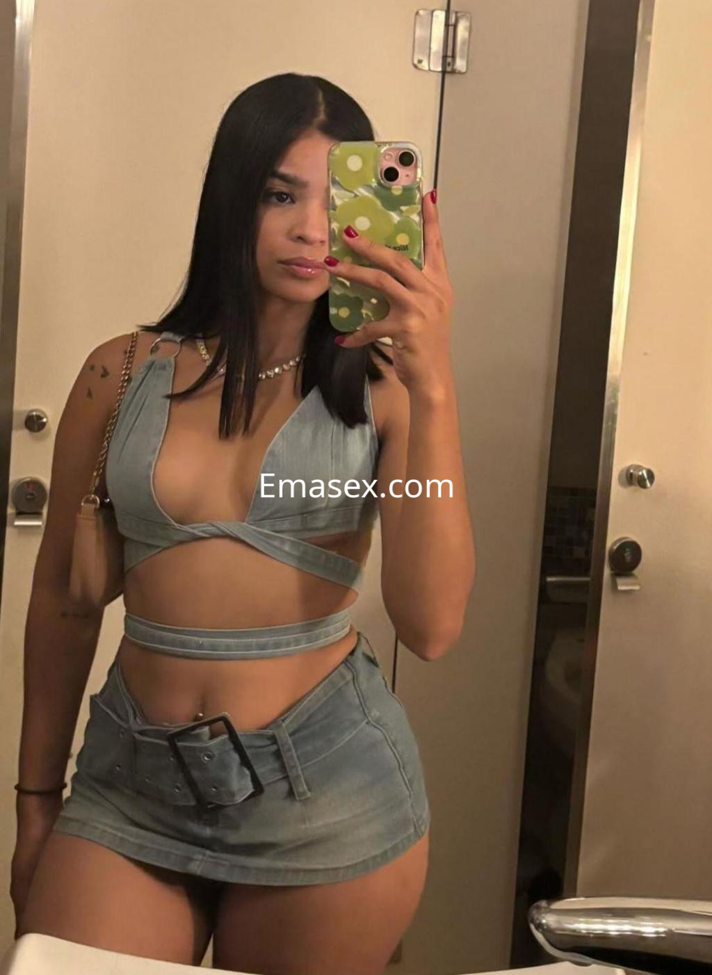 Puta con cabello largo y lacio, viste un conjunto de denim que resalta su figura en un baño de Coruña.