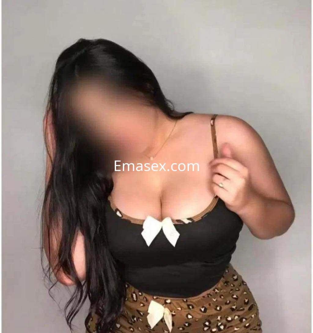 Escort en Albacete con cabello largo y oscuro, vistiendo un top negro con tirantes y un pantalón de estampado animal.