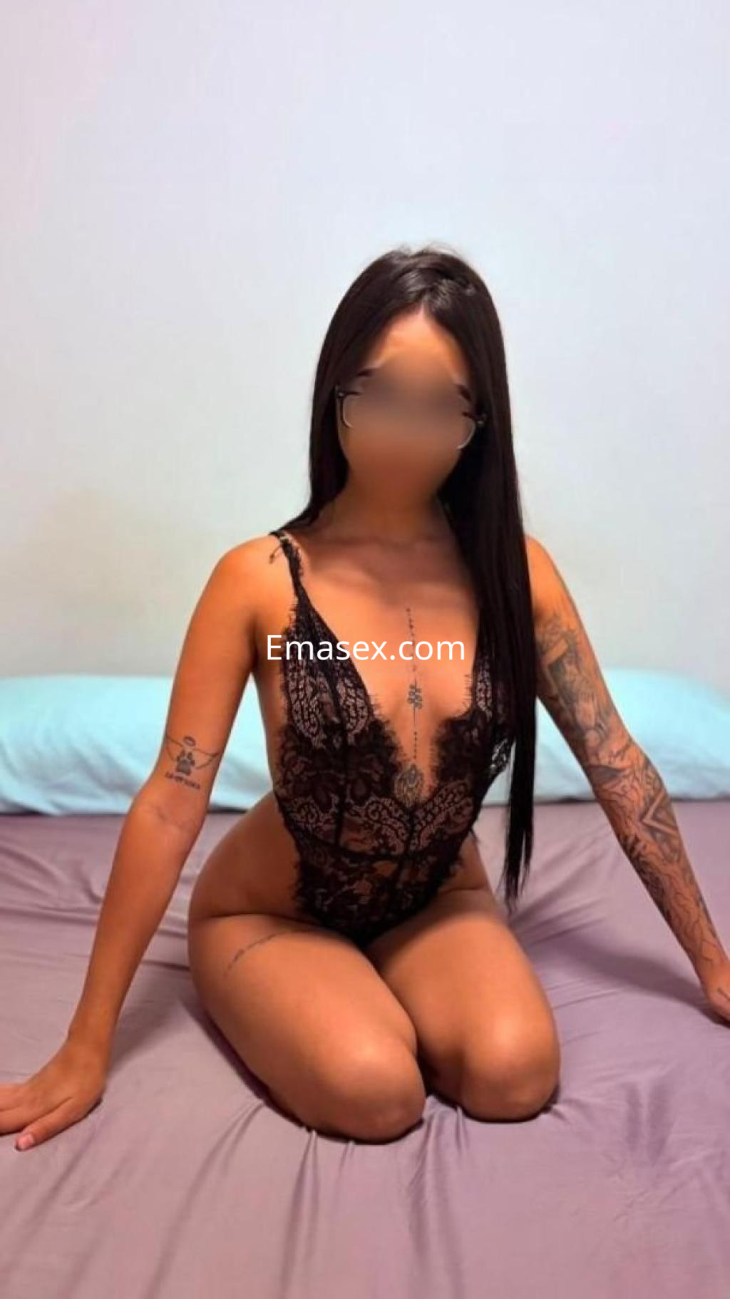 Puta con lencería negra y detalles de encaje, sentada sobre una cama en Tarragona, con cabello largo y lacio.