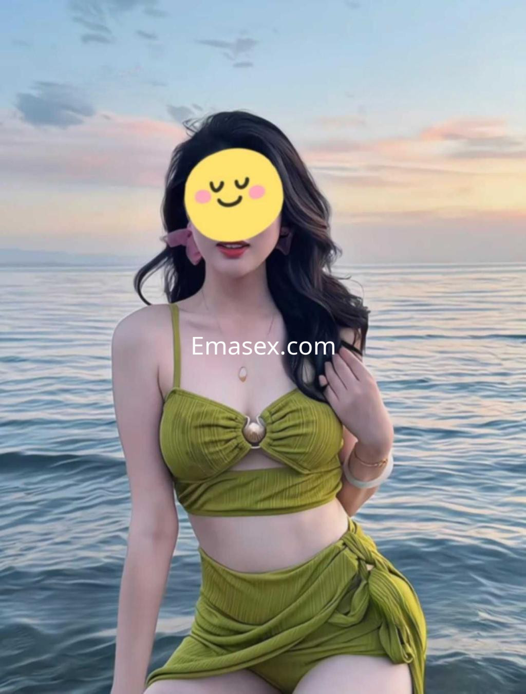 Puta posando en la playa de Valencia, viste un conjunto verde y muestra una actitud relajada frente al mar.
