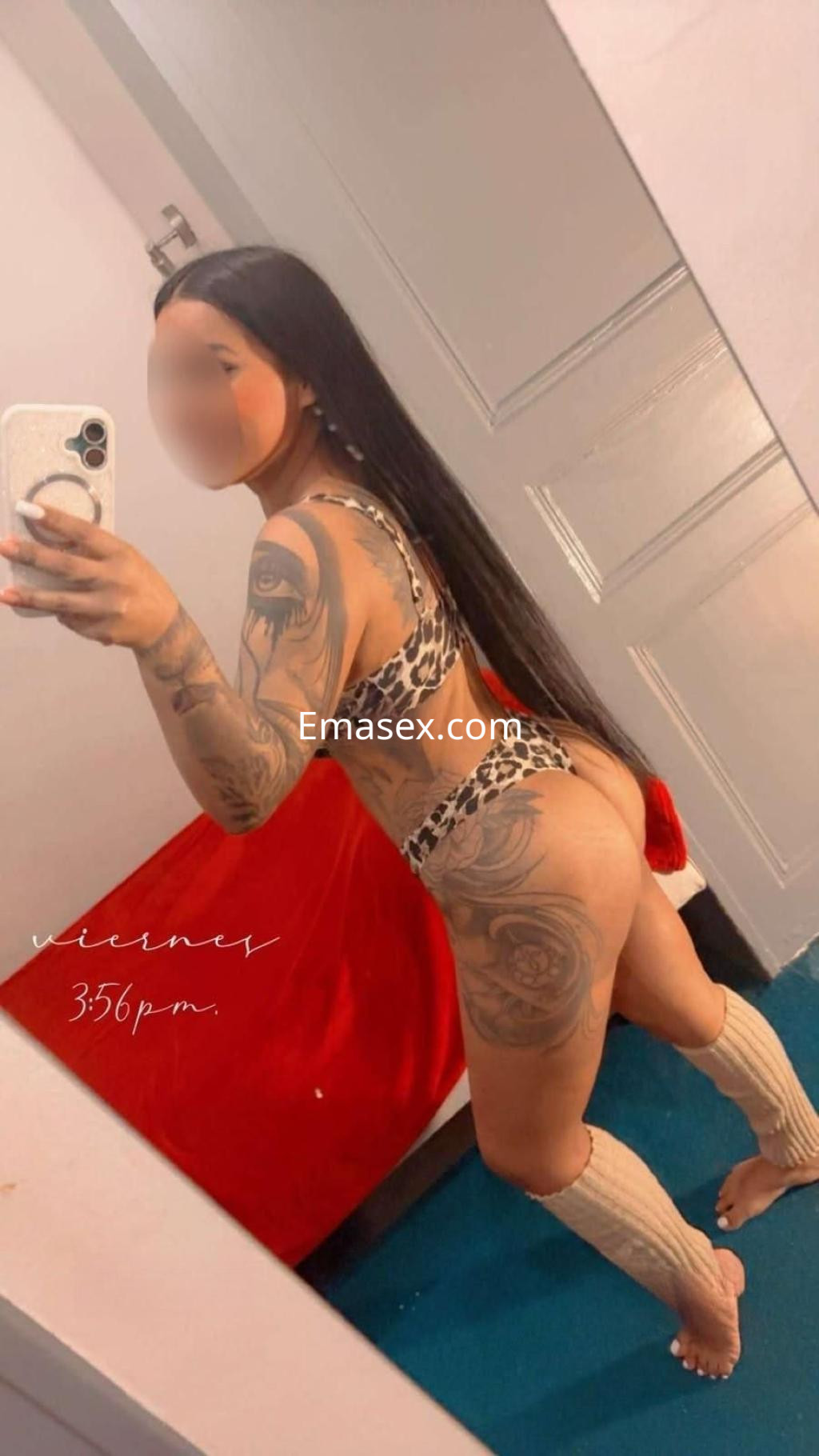 La puta está de espaldas con un bikini de leopardo, mostrando sus tatuajes y cabello largo en Almería.