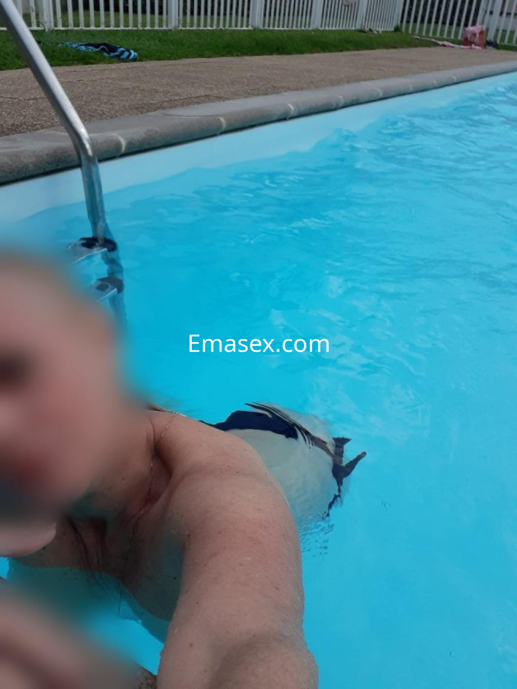 Escort en Lugo posando en una piscina, mostrando parte de su torso y el agua azul de fondo.