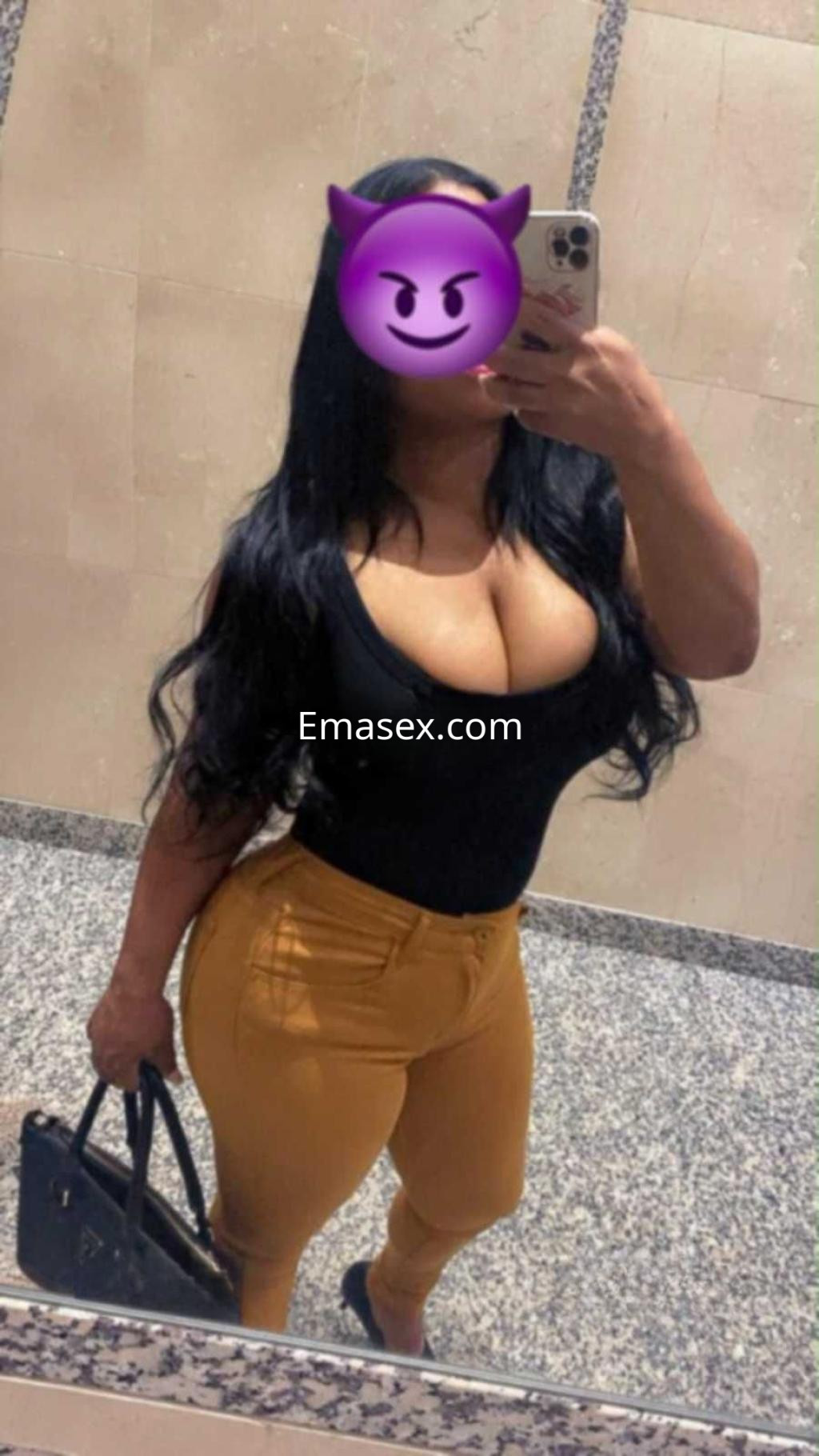 Escort en Pontevedra con cabello largo y oscuro, luciendo un top negro y pantalones ajustados amarillos.