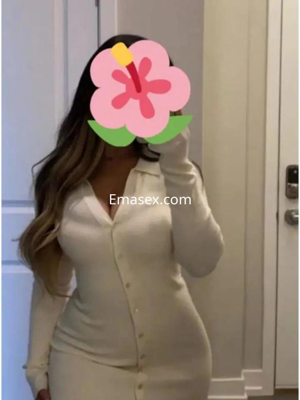Escort en Salamanca con cabello largo y ondulado, vistiendo un vestido blanco ajustado y de manga larga.
