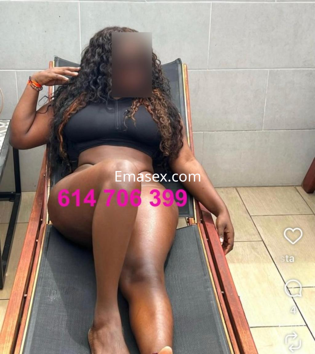 Puta de piel morena y cabello rizado, en traje de baño, recostada en una tumbona en Granada.