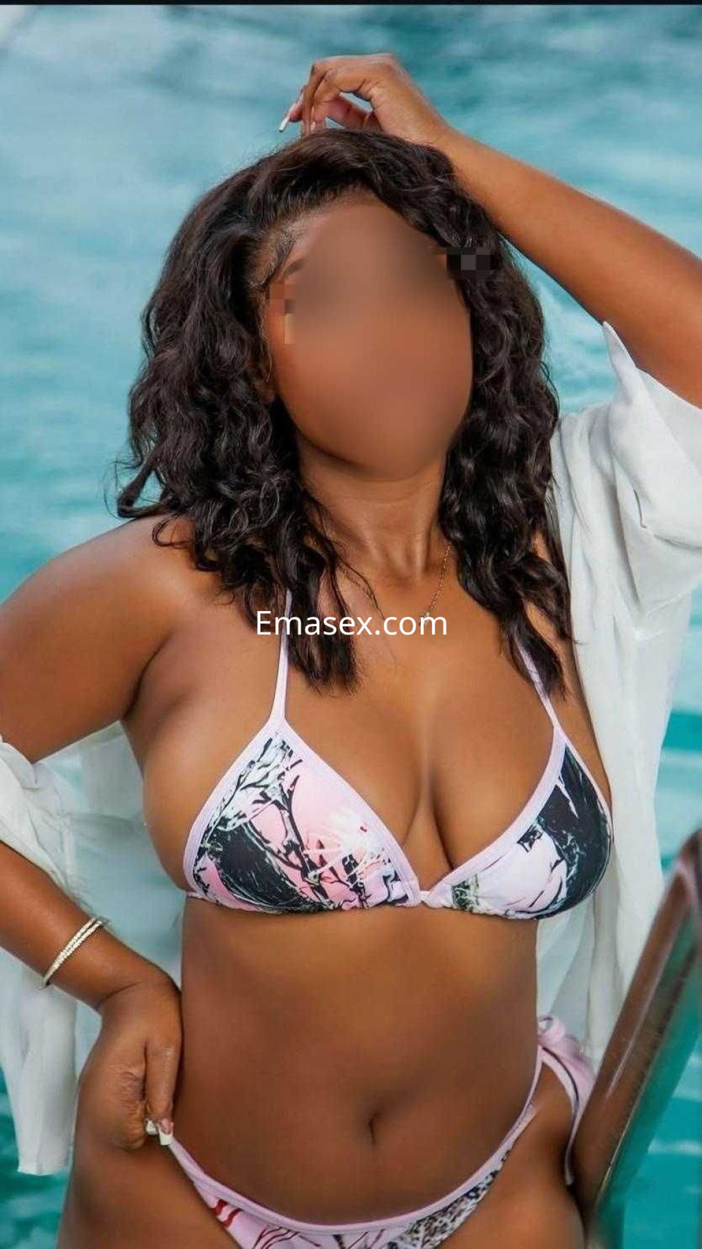 Escort en Pontevedra posando junto a una piscina, vistiendo un bikini rosa y una camisa blanca abierta.