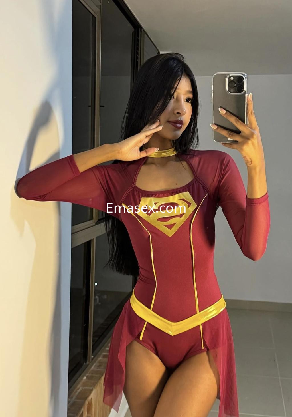 La puta se toma una selfie en Bilbao, luciendo un traje de superhéroe rojo con detalles dorados y cabello largo.