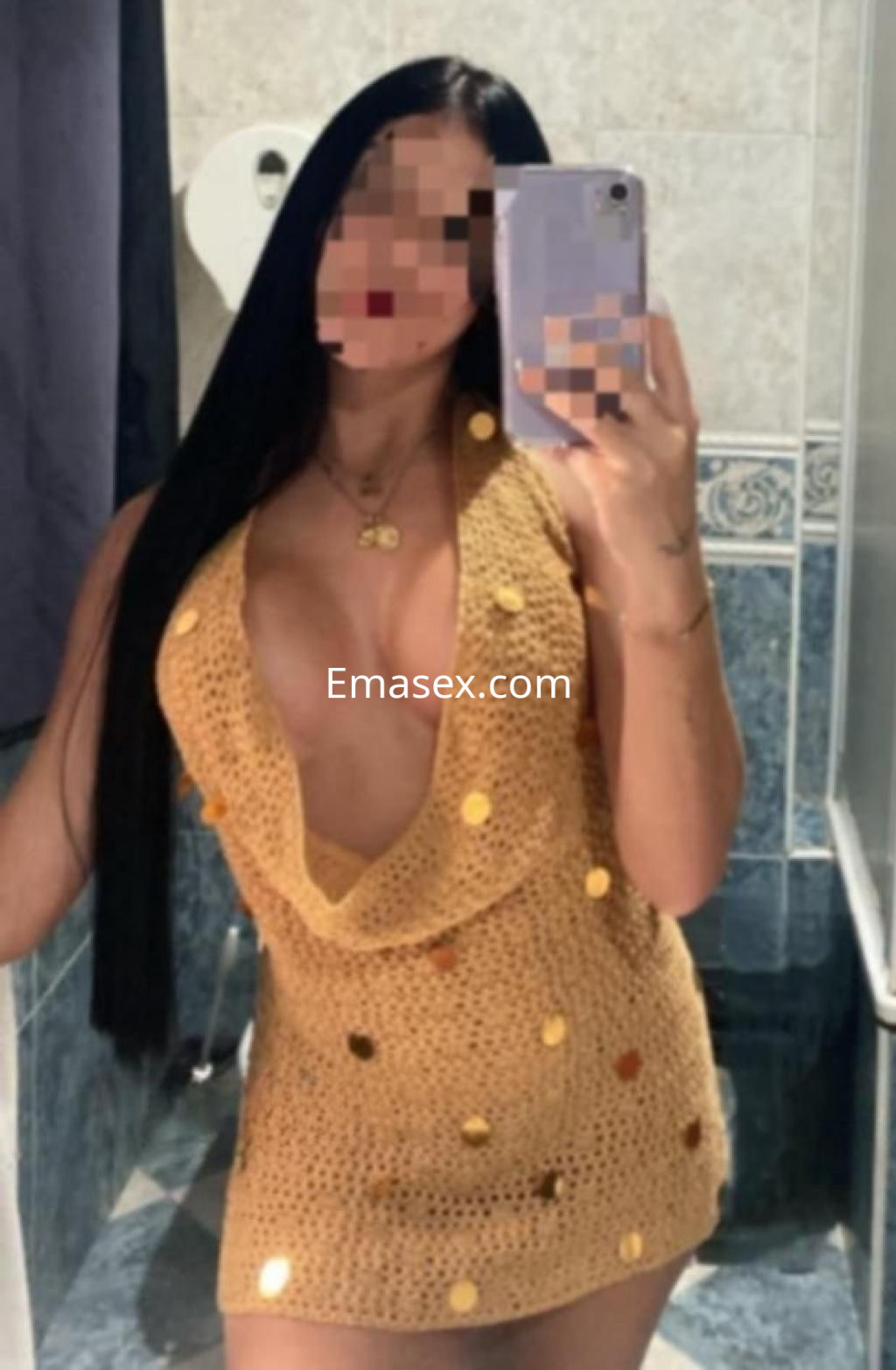 Escort en Ibiza posando frente al espejo, vistiendo un vestido de ganchillo dorado con detalles brillantes.