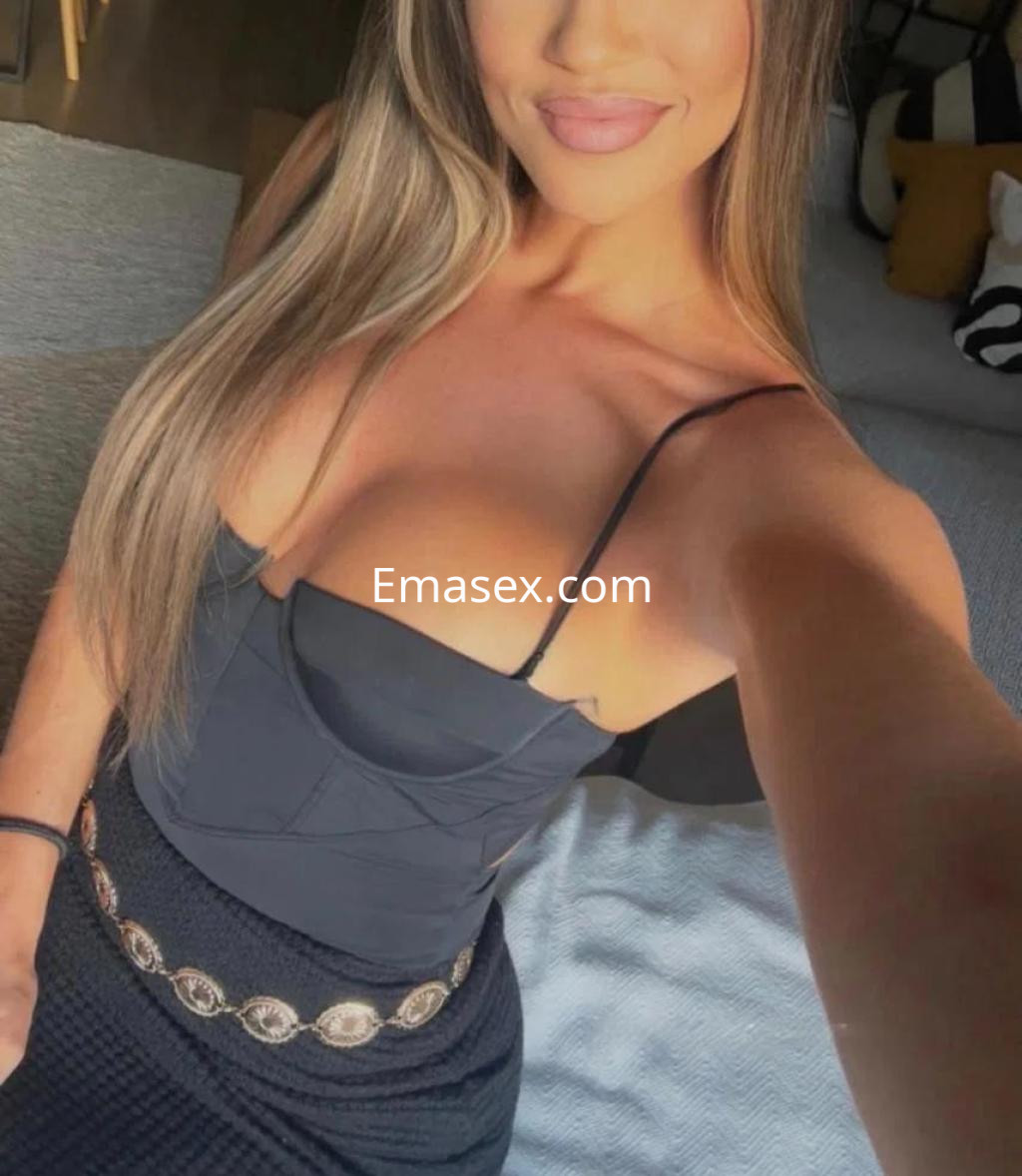 Escort en Tarragona con cabello largo y lacio, viste un top negro ajustado y una falda con cinturón decorativo.