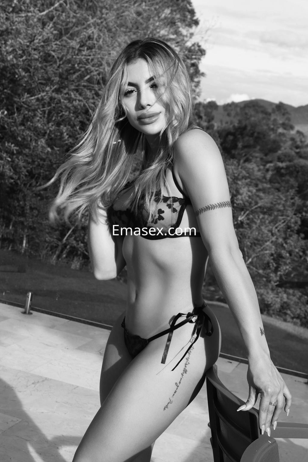 La puta posa en un entorno natural con cabello suelto y un bikini negro, mostrando su figura esculpida en Logroño.