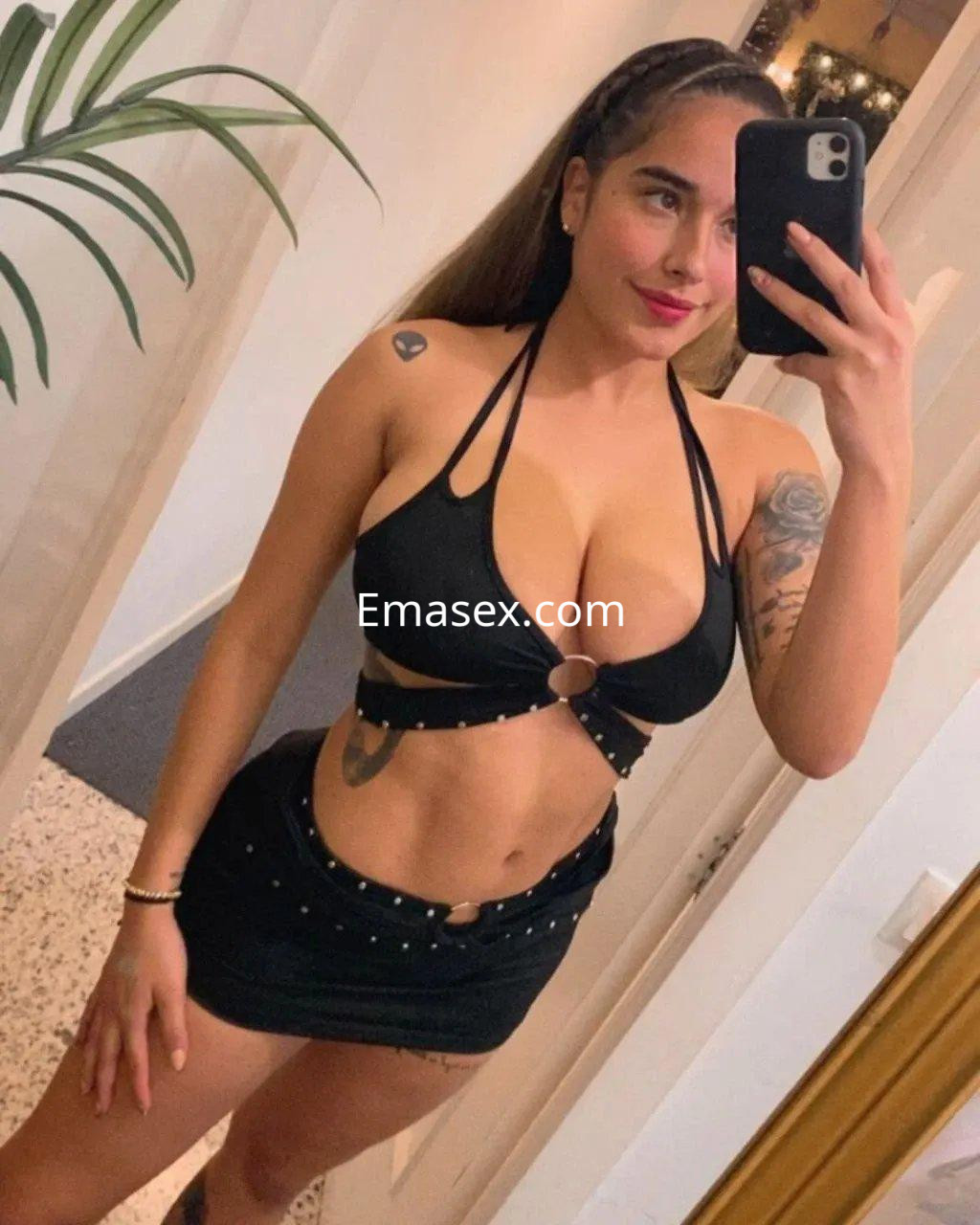 La escort en Palma de Mallorca posa con un top negro y una falda corta, luciendo un peinado largo y lacio.