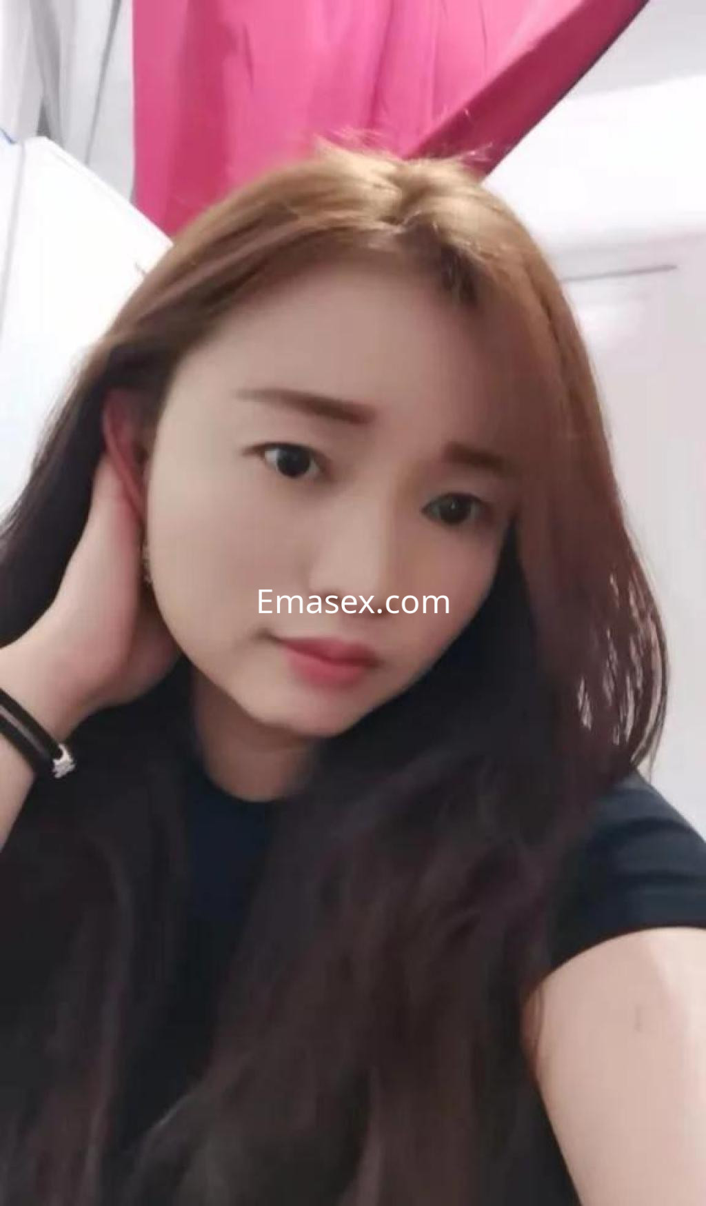 Escort en Barcelona con cabello largo y lacio, vistiendo una camiseta negra, posando de forma casual.