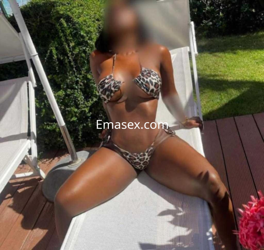 Escort en Lugo, relajada en una tumbona, luciendo un bikini de estampado de leopardo y con piel bronceada.