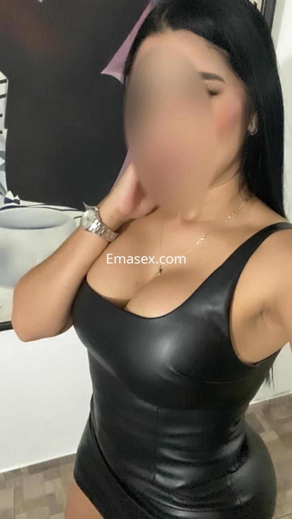 Puta en Valencia luciendo un ajustado vestido de cuero negro que resalta su figura, con cabello largo y oscuro.