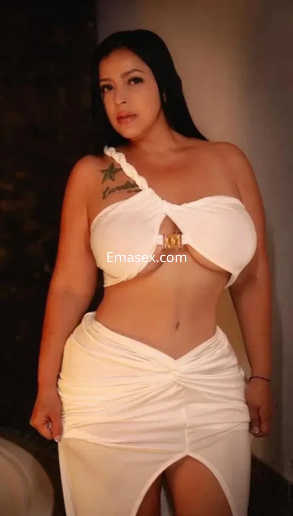 Escort en Albacete vestida con un top blanco ajustado y una falda que revela una pierna, con cabello largo y lacio.