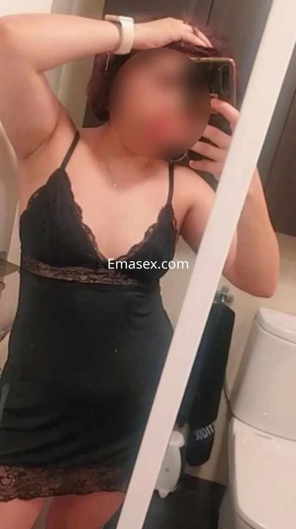 Puta en Bilbao posando con un vestido negro de encaje, mostrando una actitud coqueta y segura frente al espejo.