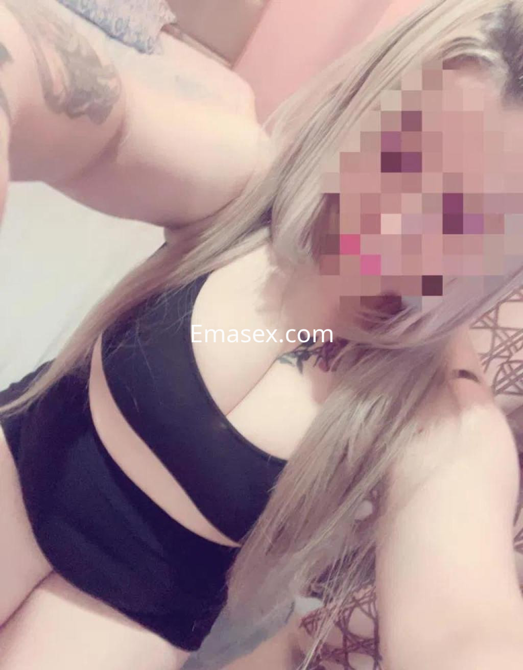Escort en Madrid con cabello largo y lacio, vestida con un conjunto de lencería negro en un ambiente acogedor.