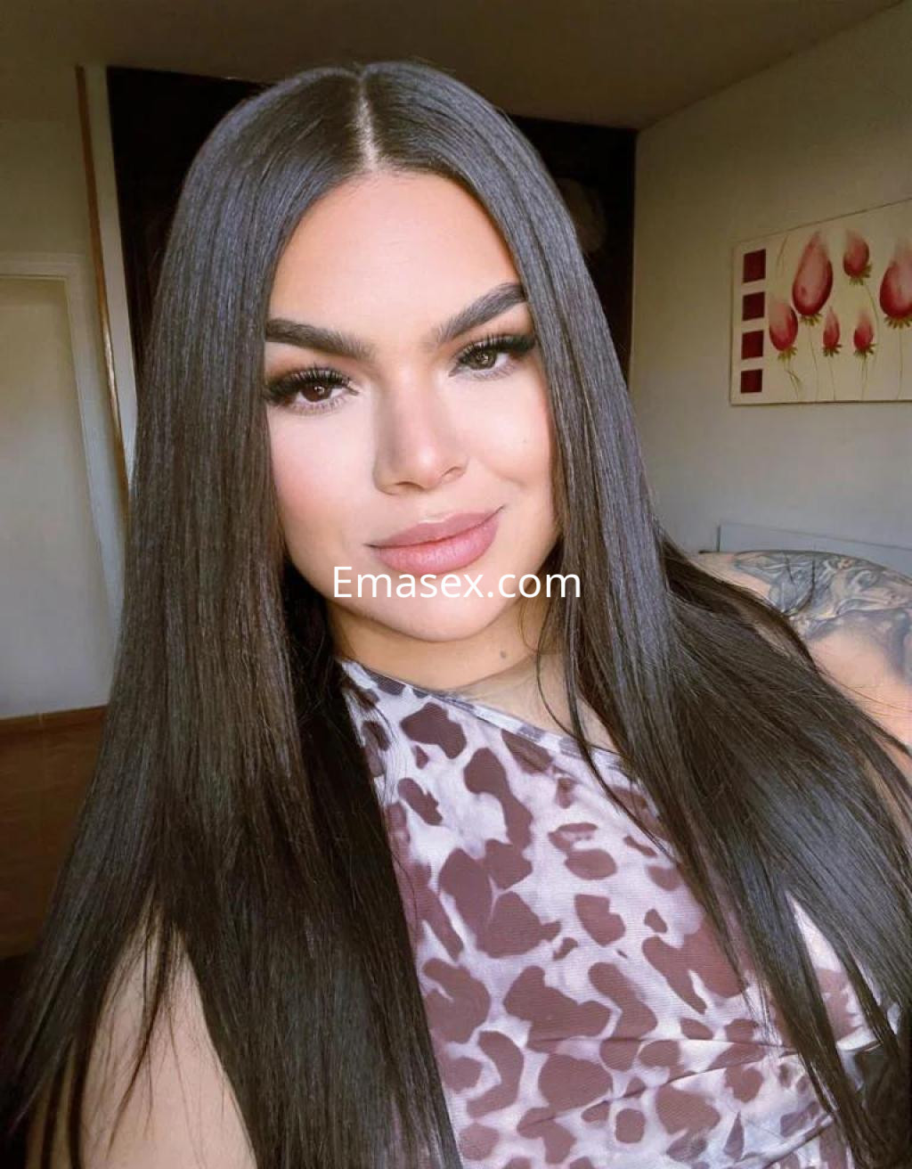 Escort en Valladolid con cabello largo y lacio, luciendo una blusa de estampado animal y un maquillaje destacado.