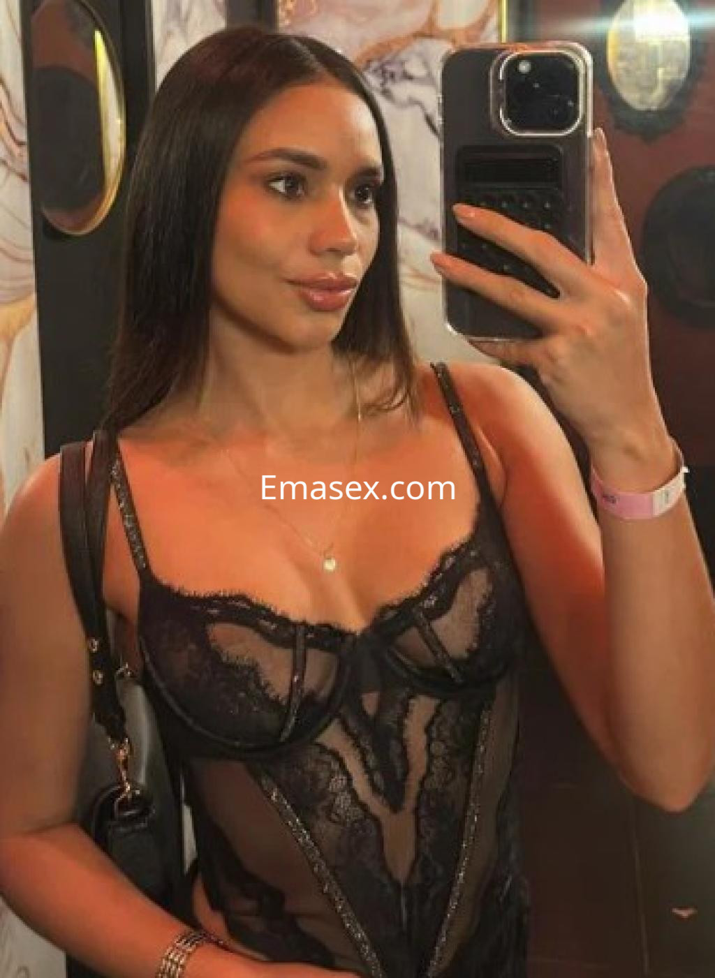 La puta se toma un selfie en un espejo, vistiendo un body de encaje negro en un entorno elegante de Málaga.