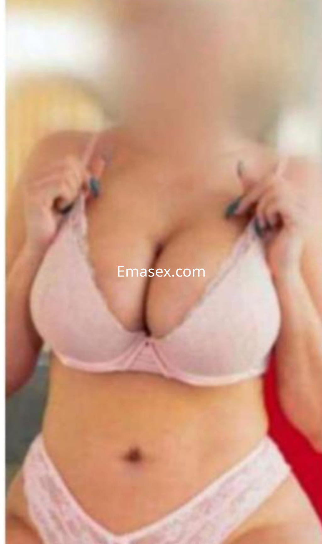 Escort en Donosti posando con lencería rosa, mostrando un escote pronunciado y con una actitud coqueta.