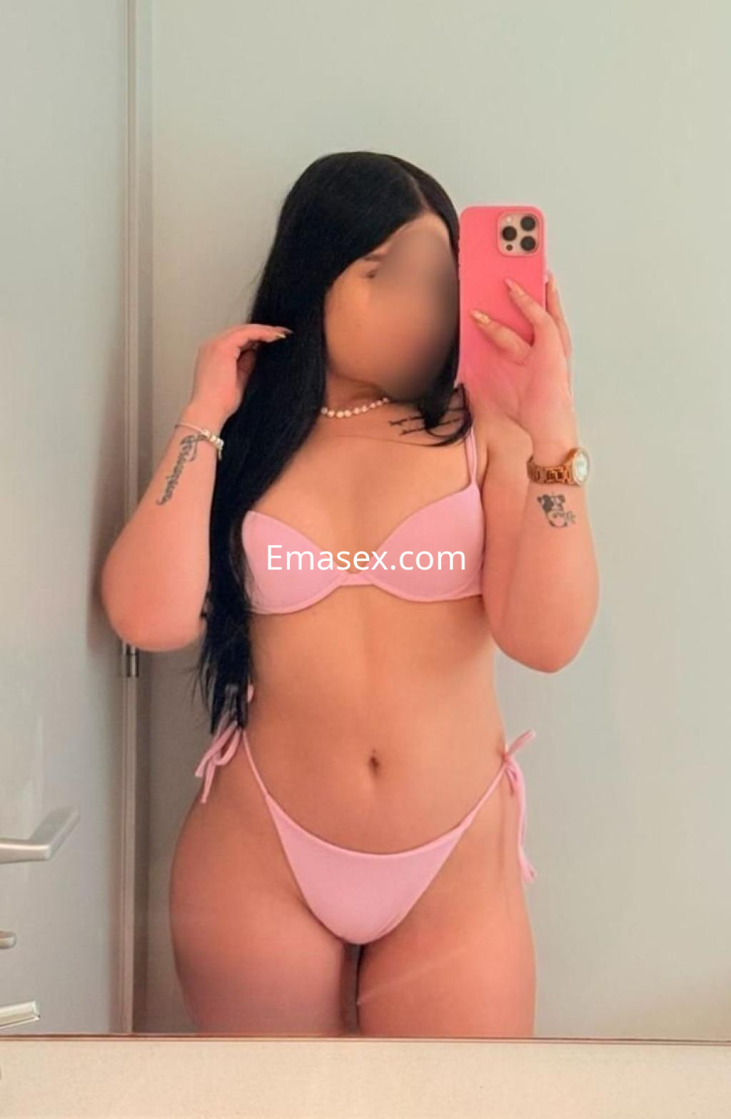 Puta de cabello largo y lacio, viste un bikini rosa y se toma una selfie en un baño en Ibiza.