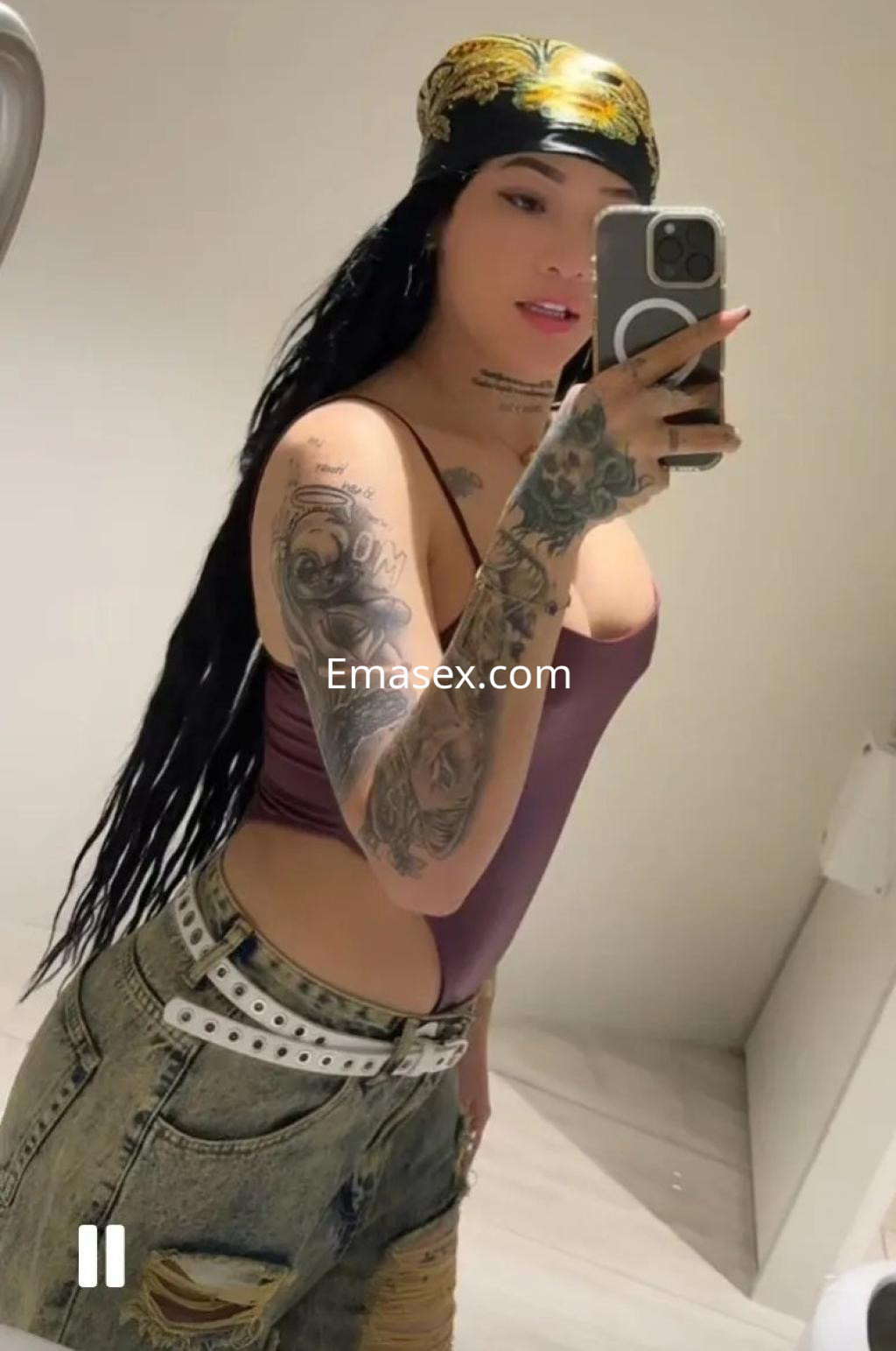 La puta posando con un body morado y pantalones cortos, mostrando sus tatuajes y un pañuelo en la cabeza en Córdoba.