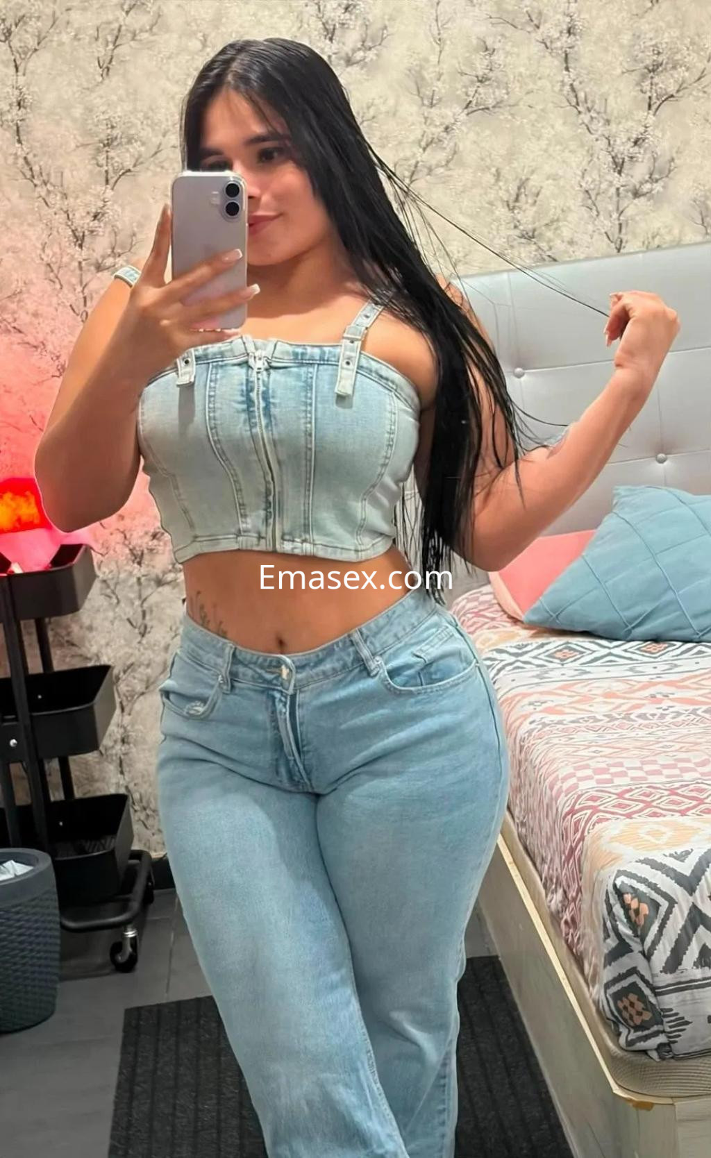 Puta posando en Zaragoza con blusa de tirantes y pantalones de mezclilla, mostrando una figura curvilínea.