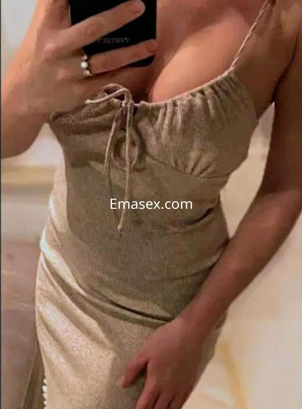 Puta en Córdoba con un vestido ajustado de tono claro, destacando su figura y un fondo suave.