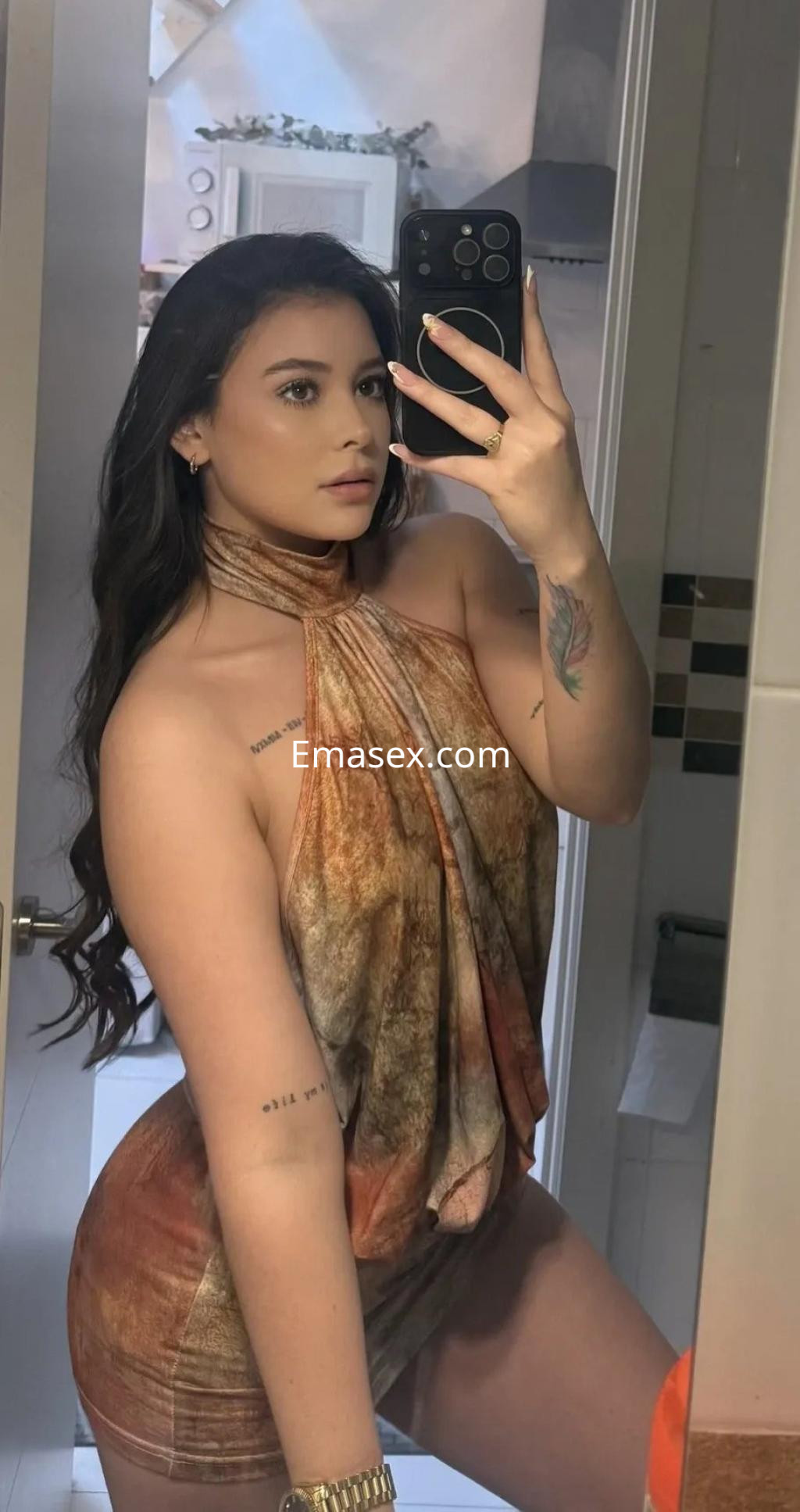 Puta en Valencia posa con un vestido corto de tonos marrones y un peinado de cabello largo y ondulado.
