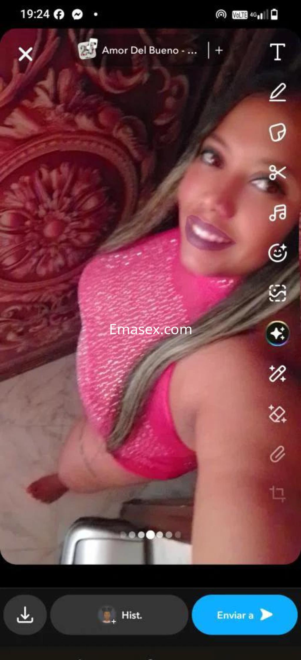 Escort en Cáceres con cabello largo y lacio, vistiendo un top brillante de color rosa y posando con una sonrisa.