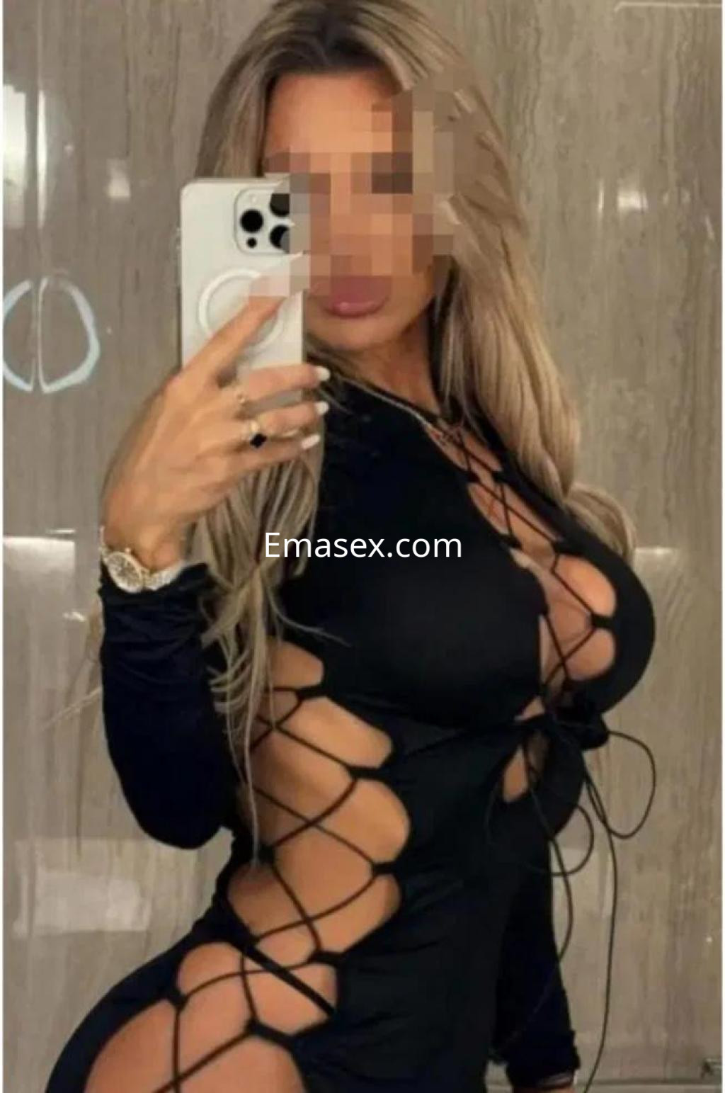 La puta en Cádiz luce un vestido negro ajustado con cortes laterales, destacando su figura y cabello rubio.