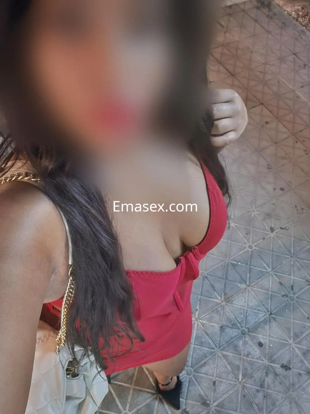 Escort en Granada luciendo un vestido rojo ajustado y tacones, con cabello largo y ondulado.