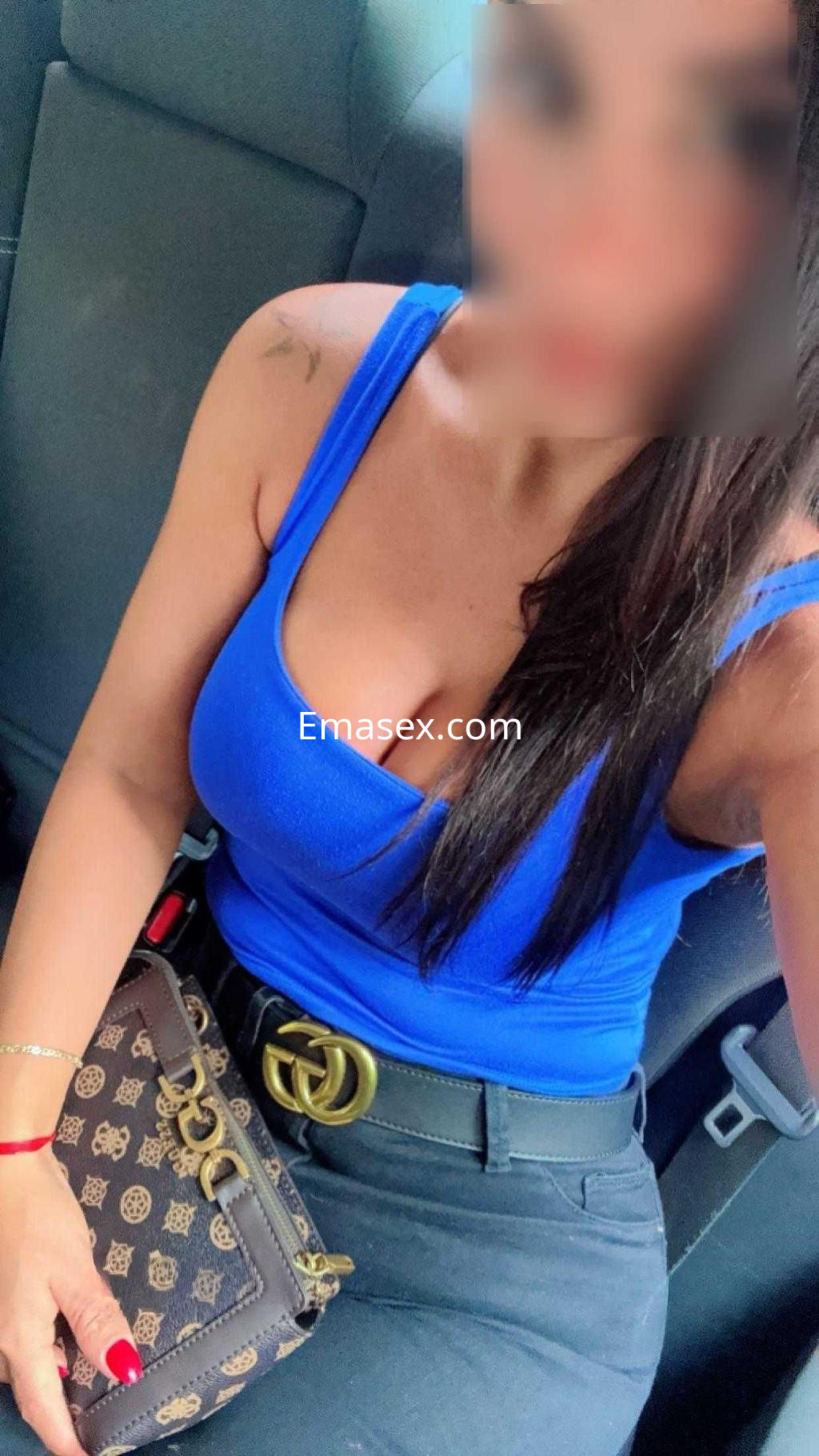 Puta con blusa azul y pantalones oscuros posando en el interior de un vehículo en Madrid.