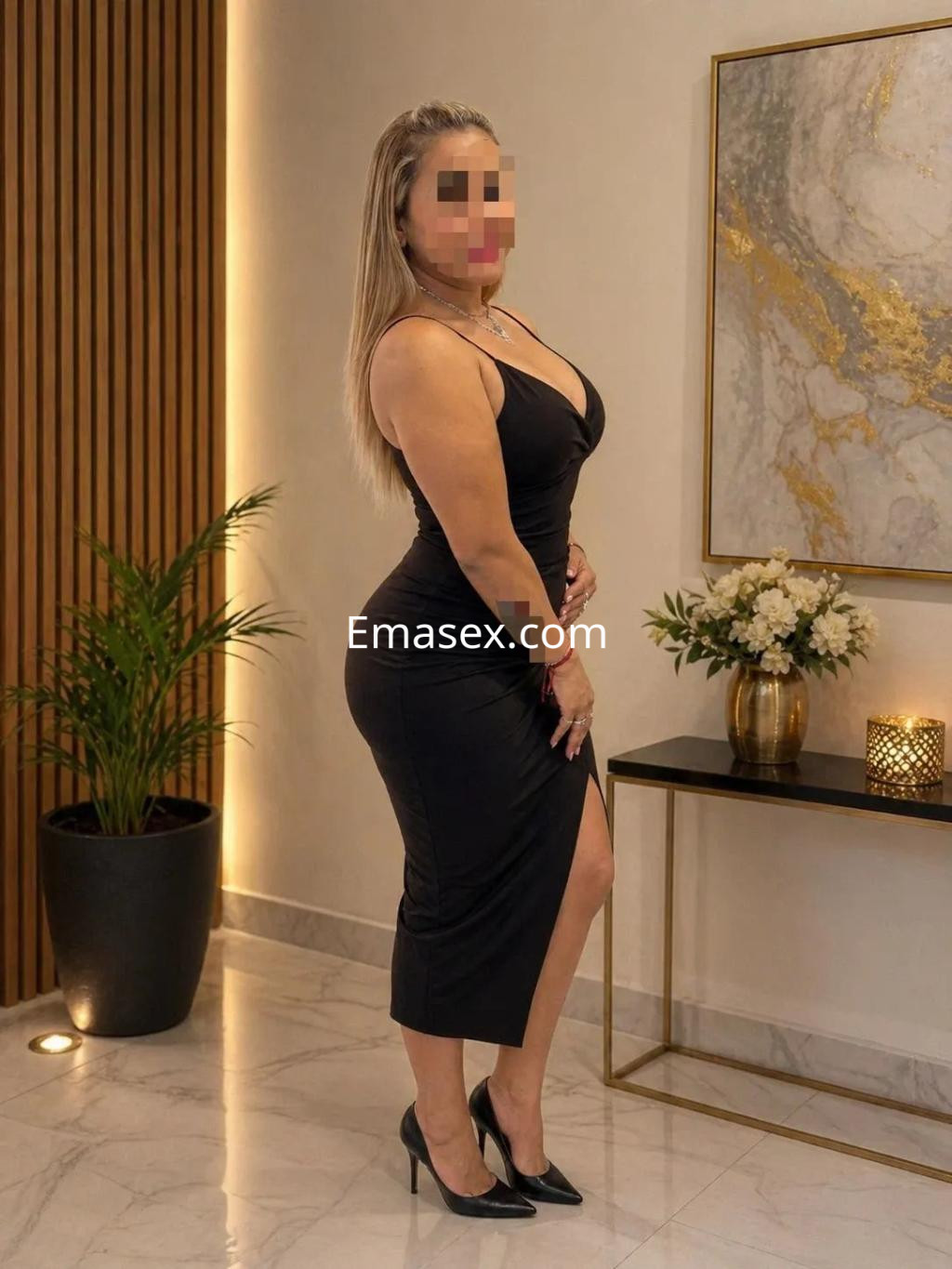Puta posando en un elegante vestido negro ajustado, con tacones altos, en un ambiente moderno de Valladolid.