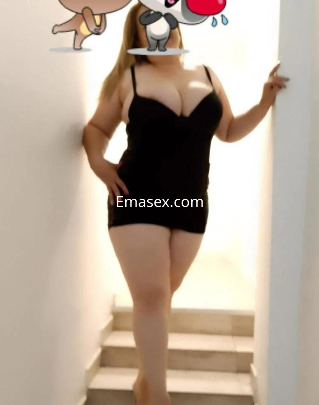 Puta de cabello largo y lacio, viste un vestido negro ajustado y posa en una escalera en Madrid.