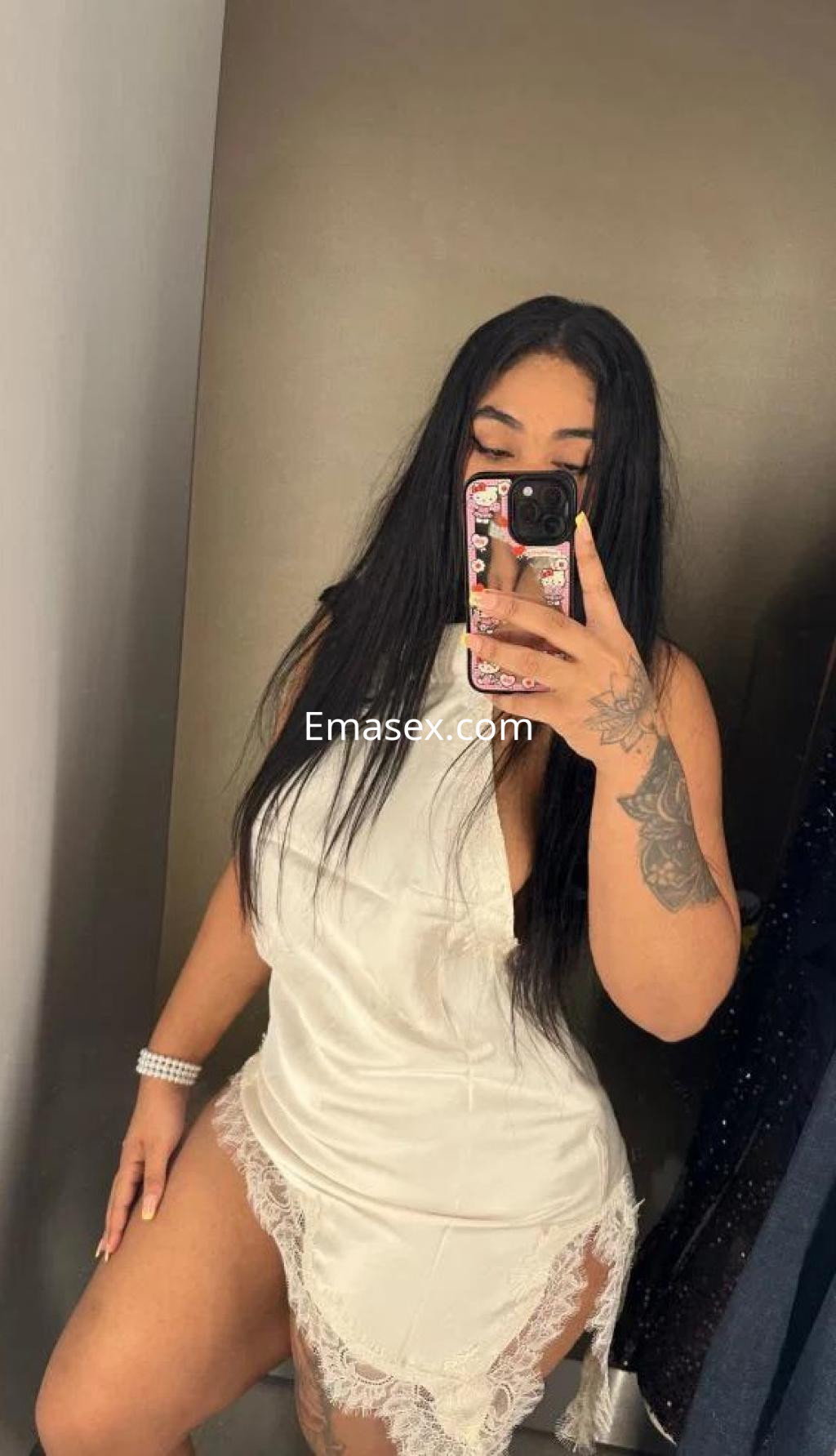 Escort en Pontevedra luciendo un vestido blanco satinado con detalles de encaje y cabello largo y oscuro.