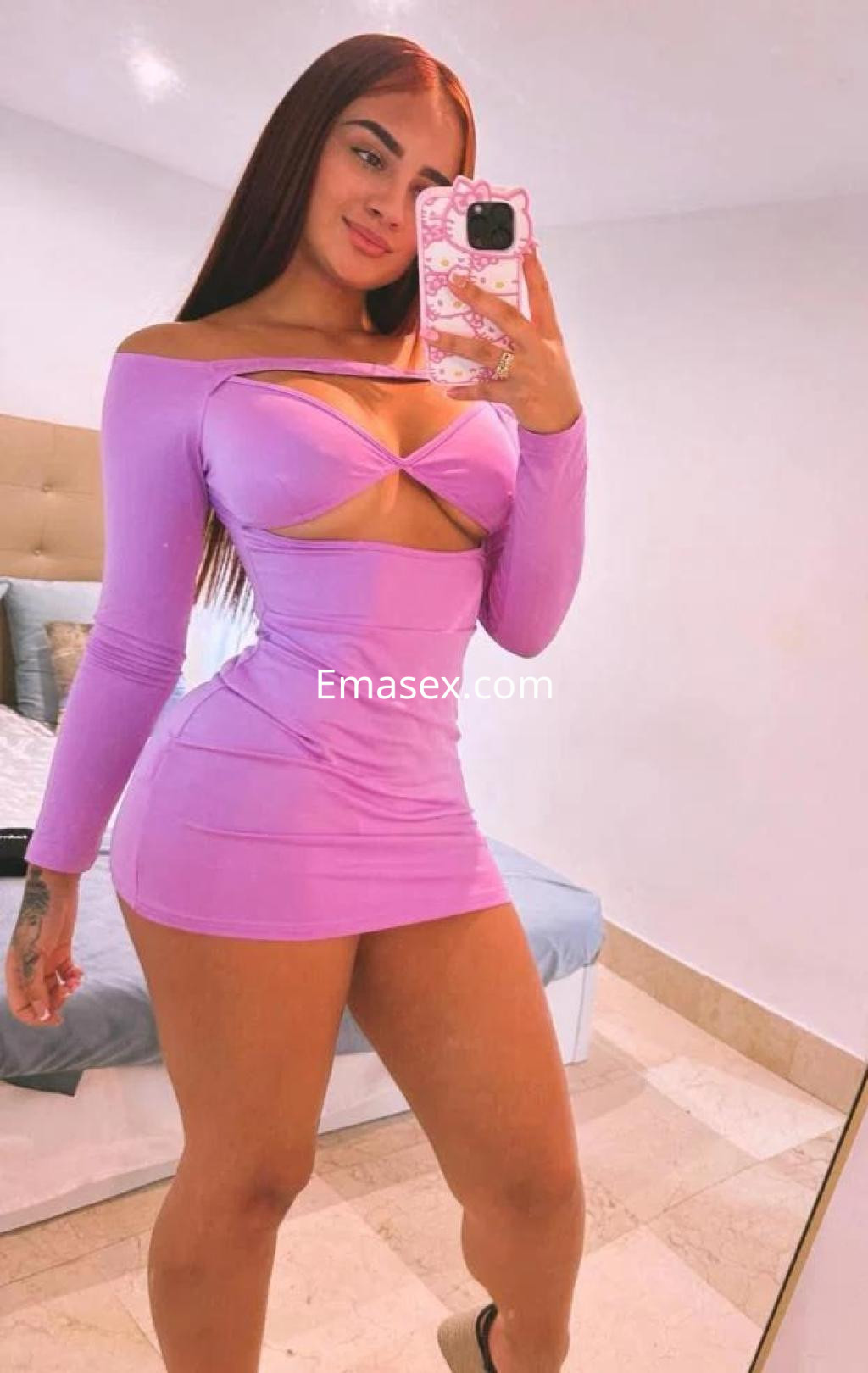 Puta en Cádiz posando con un vestido morado ajustado, mostrando su figura y con cabello largo y lacio.