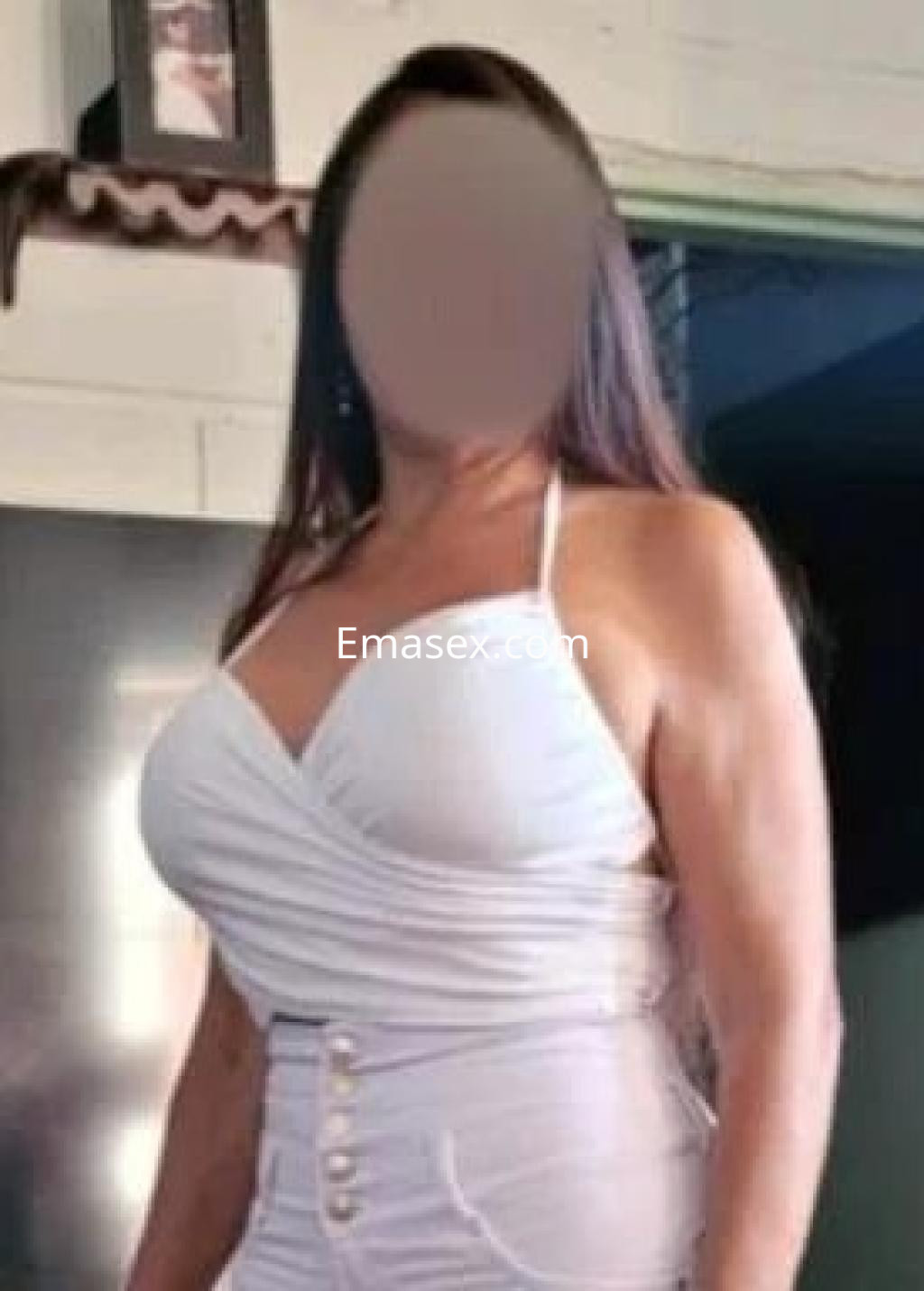 Escort en Cádiz, con vestido blanco ajustado que resalta su figura, en un ambiente interior iluminado.