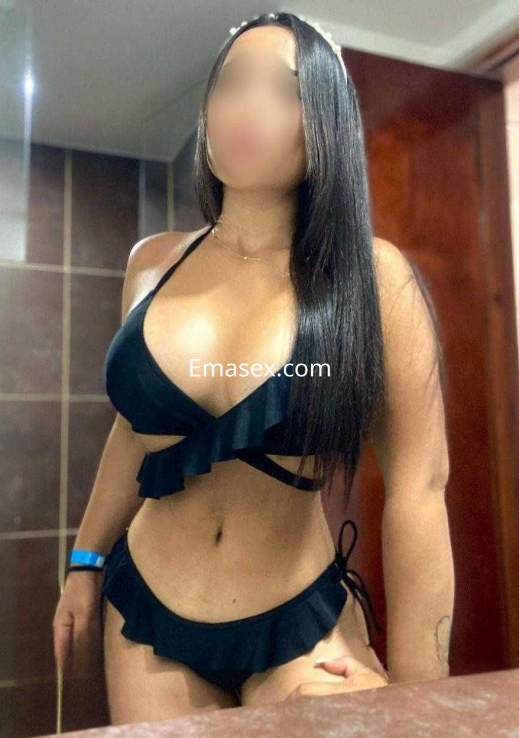 Puta en Valladolid con cabello largo y lacio, vistiendo un bikini negro con volantes, posando en un baño.