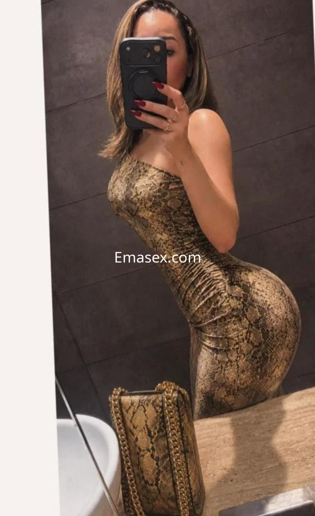 La puta posa en un vestido ajustado de estampado de serpiente frente al espejo en Tenerife.