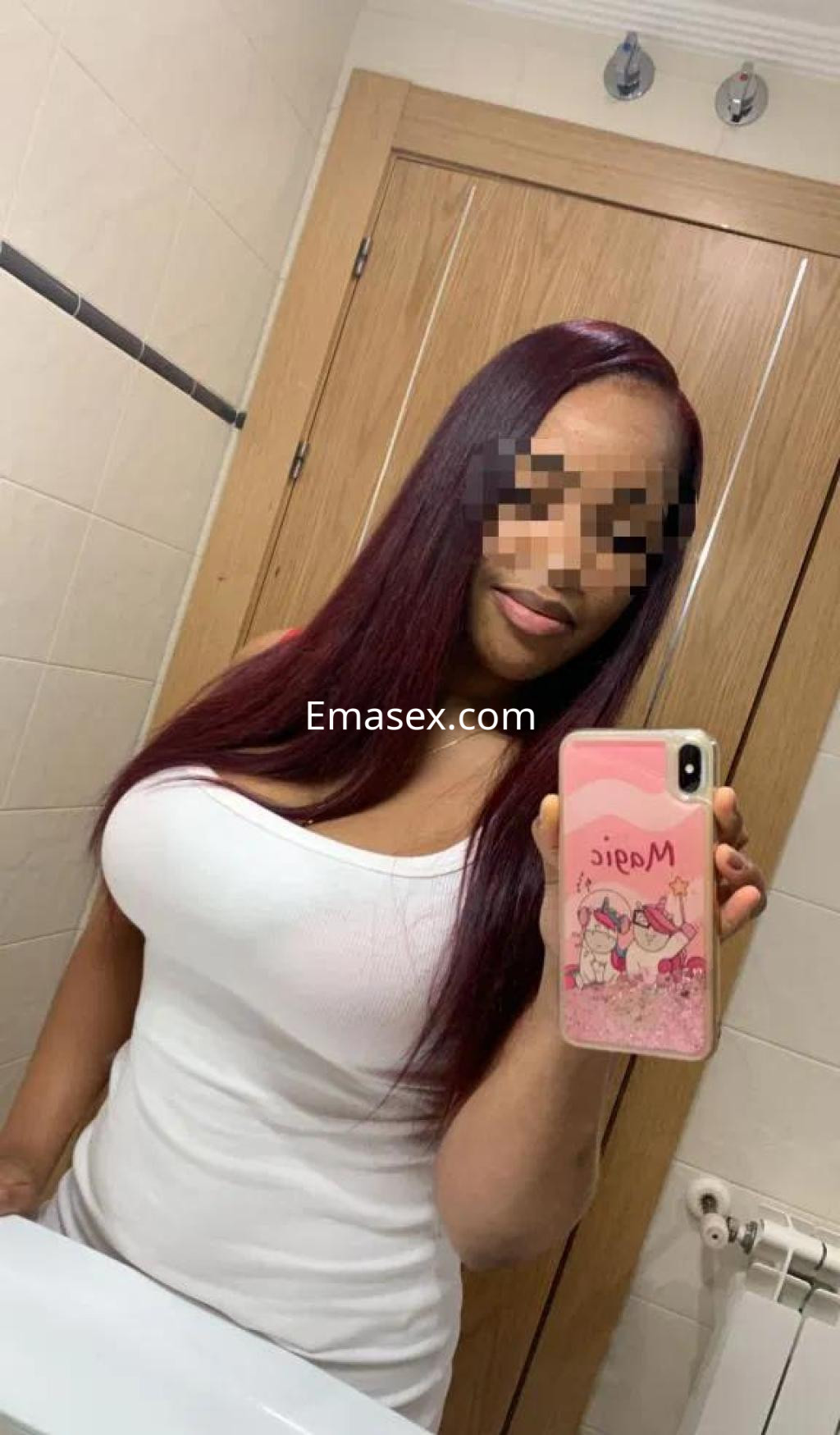 Puta de cabello largo y lacio en tonos oscuros, vestida con una camiseta blanca, en un baño de Tarragona.
