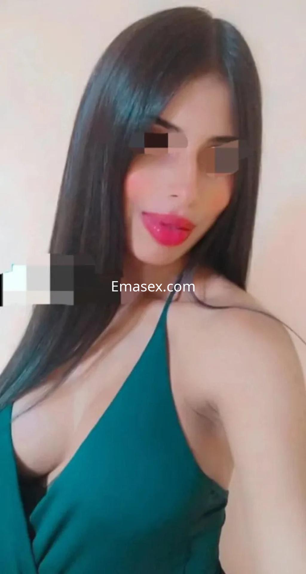 Escort en Murcia con cabello largo y oscuro, vestido verde que resalta su figura y labios pintados de rojo.