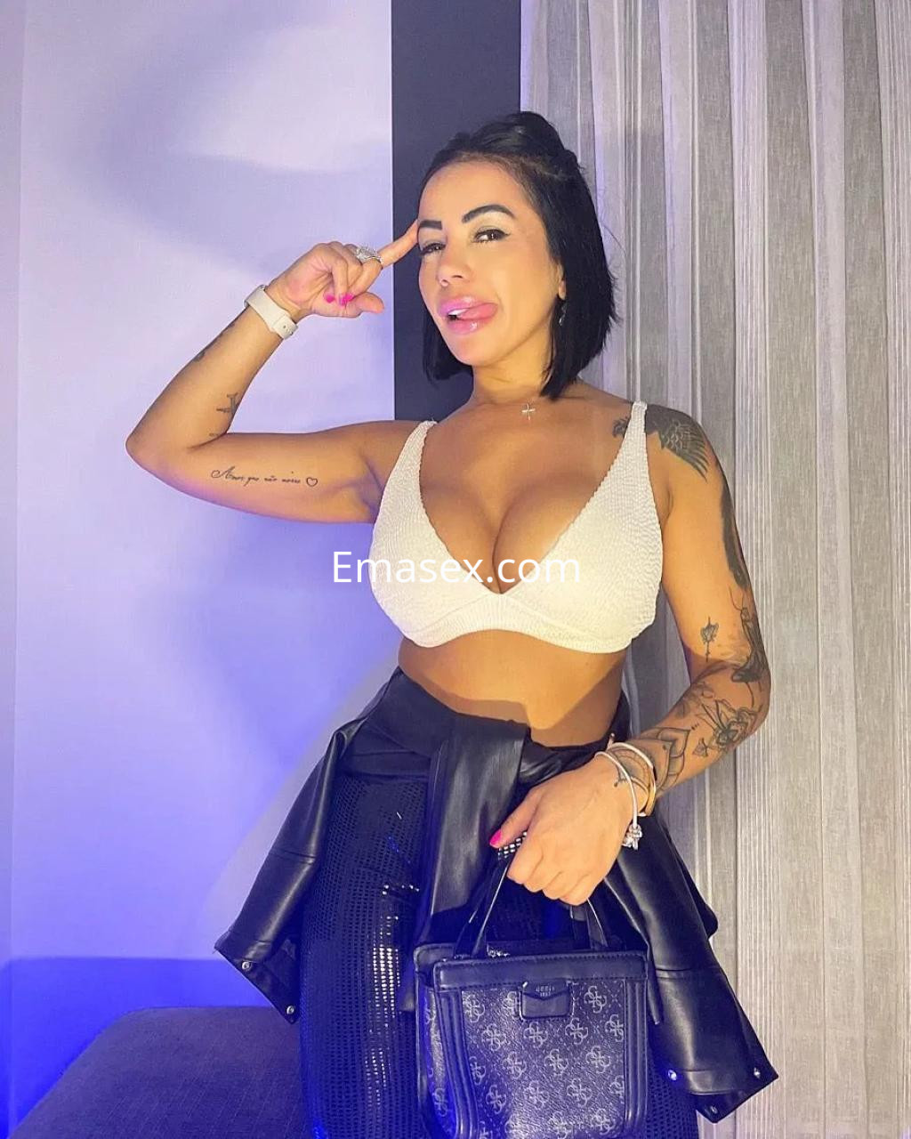 La puta en Murcia posa con un top brillante y una falda negra, mostrando su actitud segura y estilizada.