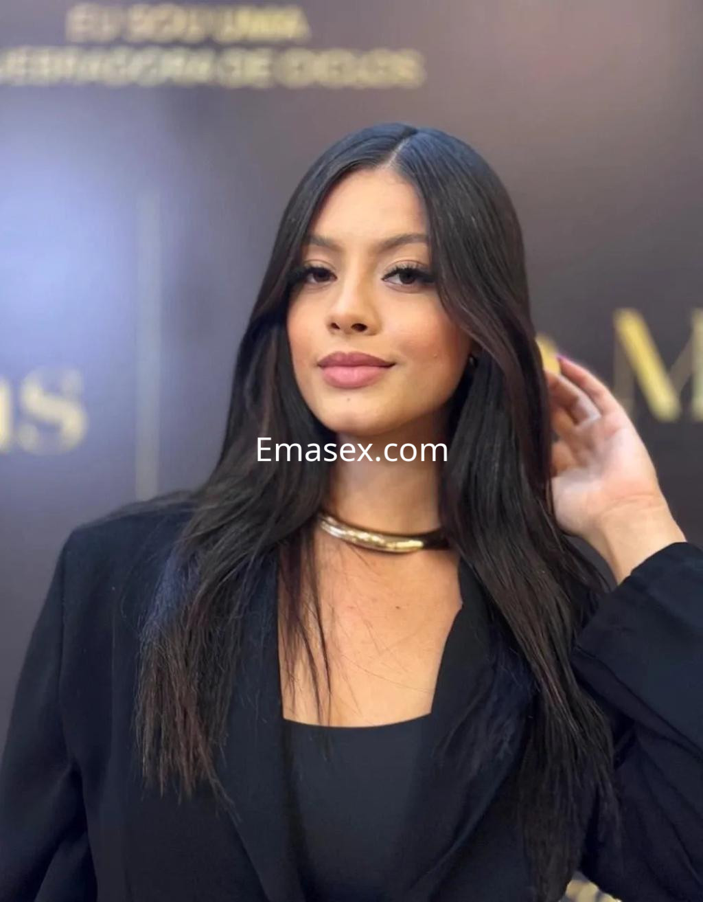 La puta luce una blusa negra y un collar dorado, con cabello largo y lacio en Alicante.