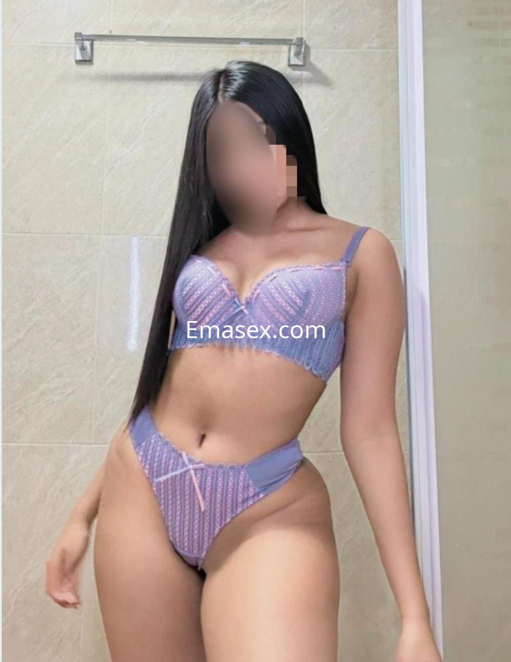 Escort en Huelva con cabello largo y lacio, vistiendo un conjunto de lencería lila con detalles brillantes.
