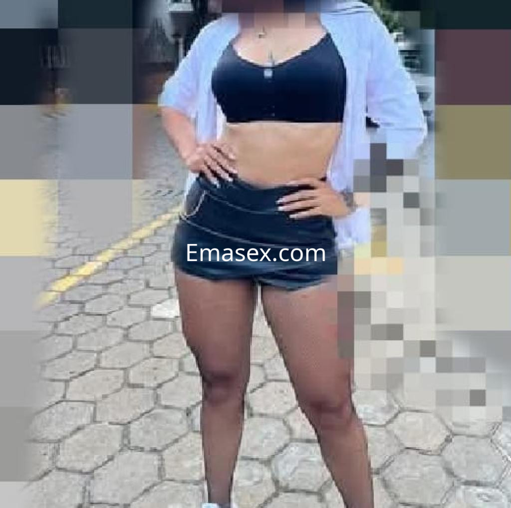 Puta en Salamanca viste un top negro y shorts cortos, mostrando su figura en un entorno urbano.