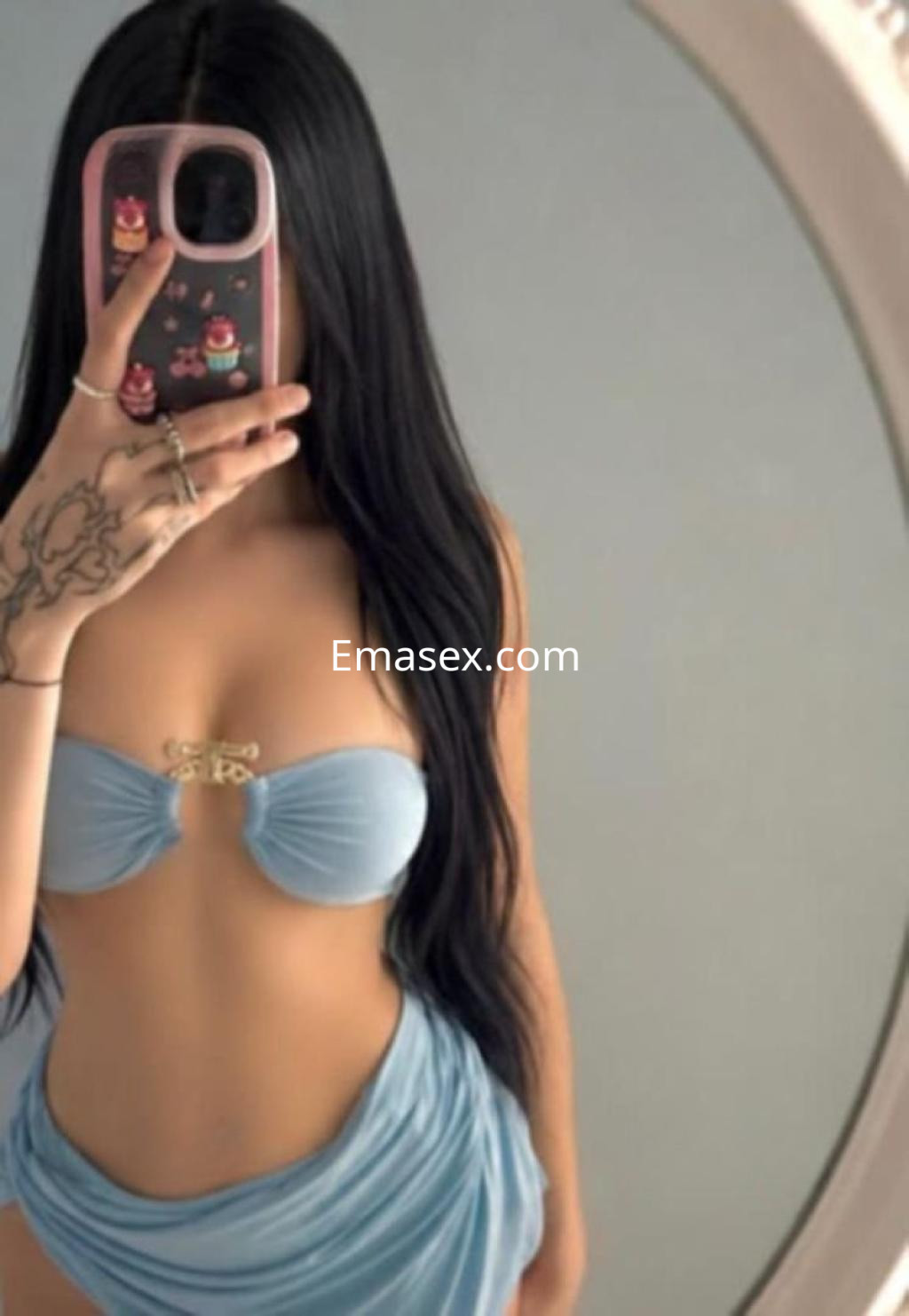 Escort en Valladolid con un bikini azul claro, mostrando su reflejo en un espejo y luciendo cabello largo.