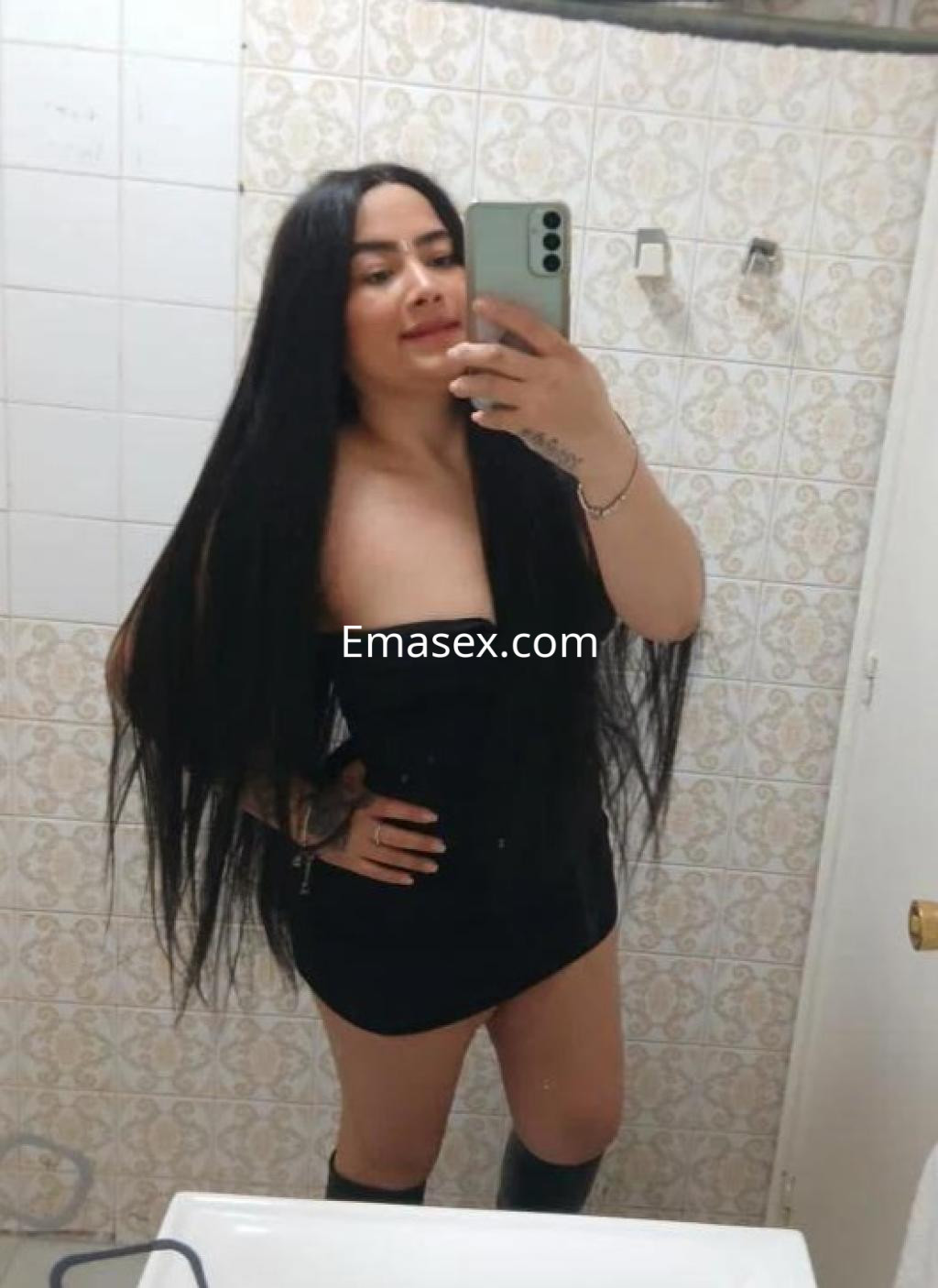 Puta con cabello largo y lacio, vestida con un vestido negro ajustado en un baño de Lleida.