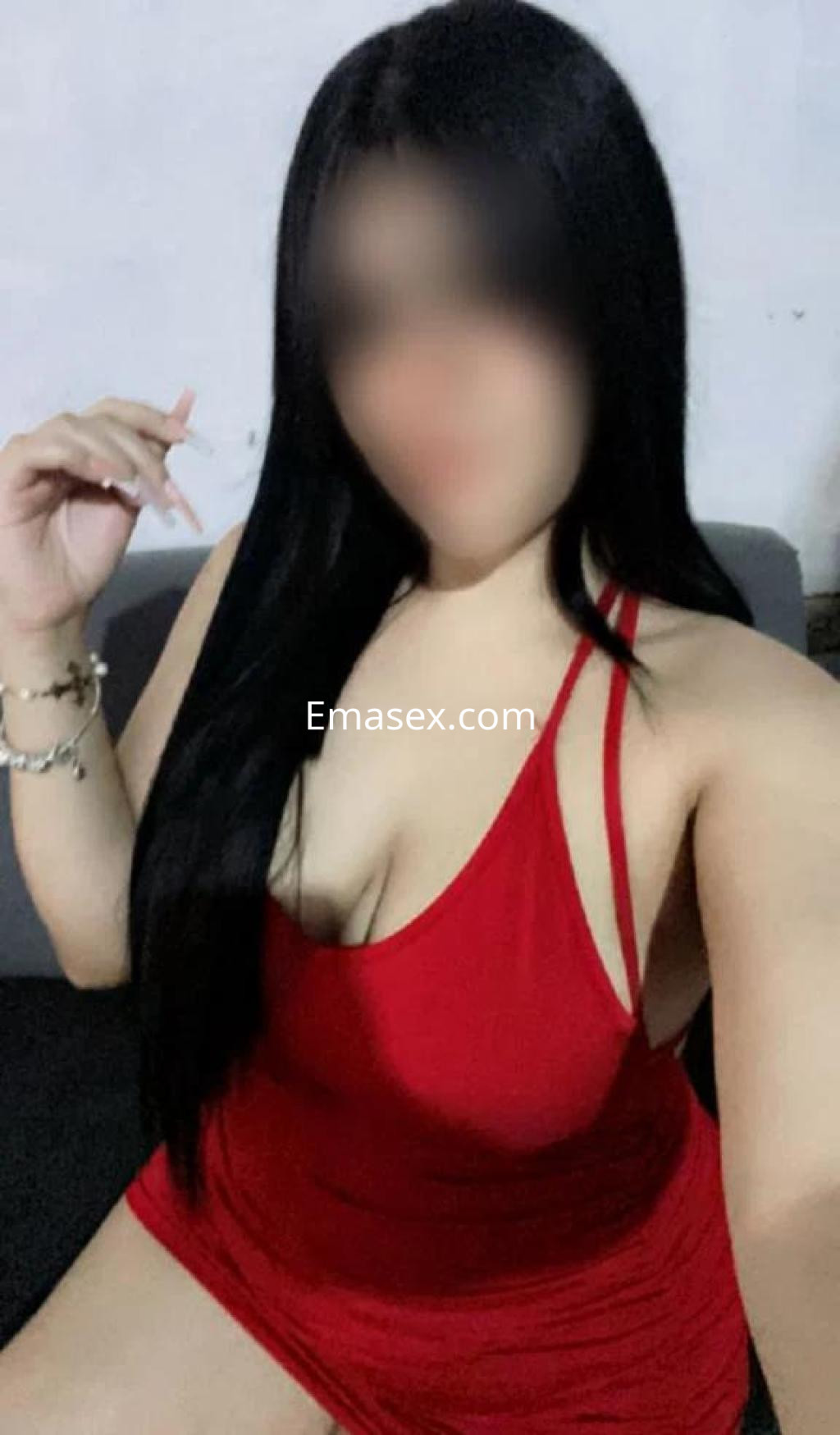 Puta en Lleida con vestido rojo ajustado, cabello largo y lacio, posando de manera sugerente.