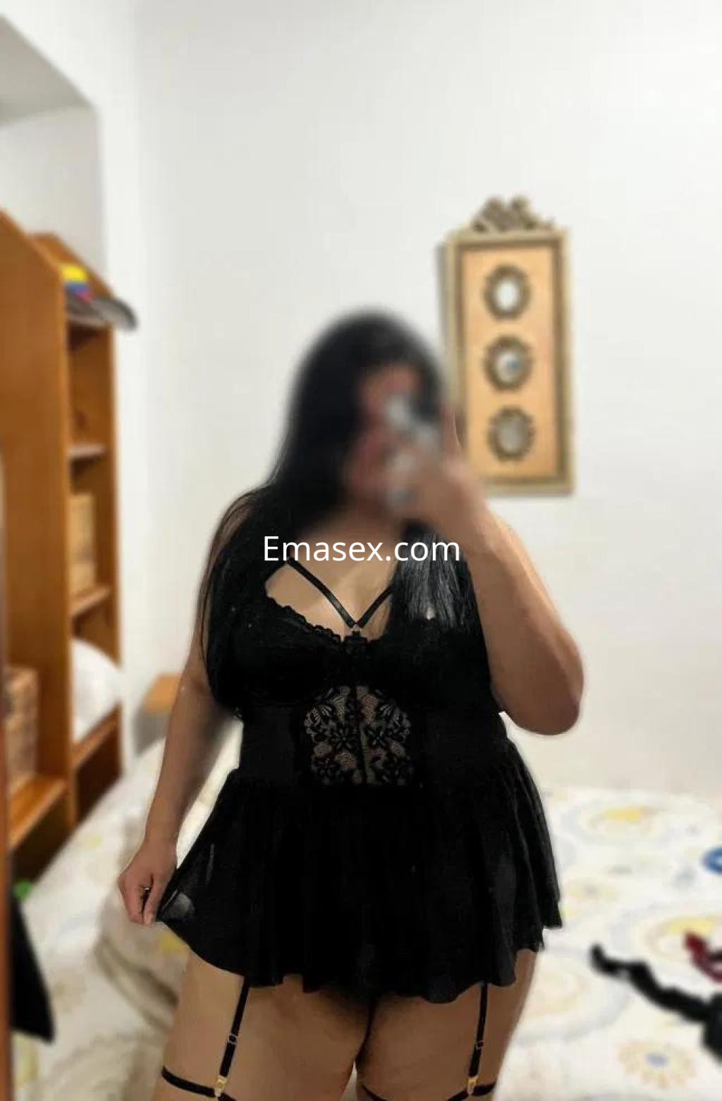 Escort en Pontevedra luciendo un conjunto de lencería negra con encaje, en un ambiente doméstico.